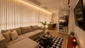 A modern living room with a sofa, coffee table, and a patterned rug. - Apartamentos HEM (Medellín)