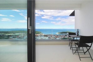 Ein Balkon mit Blick auf das Meer und eine Stadt.