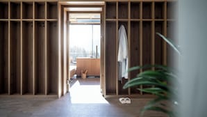 A room with a wooden wardrobe, a bench, and a pair of shoes on the floor. - Hotel Gfell (Fie allo Sciliar)
