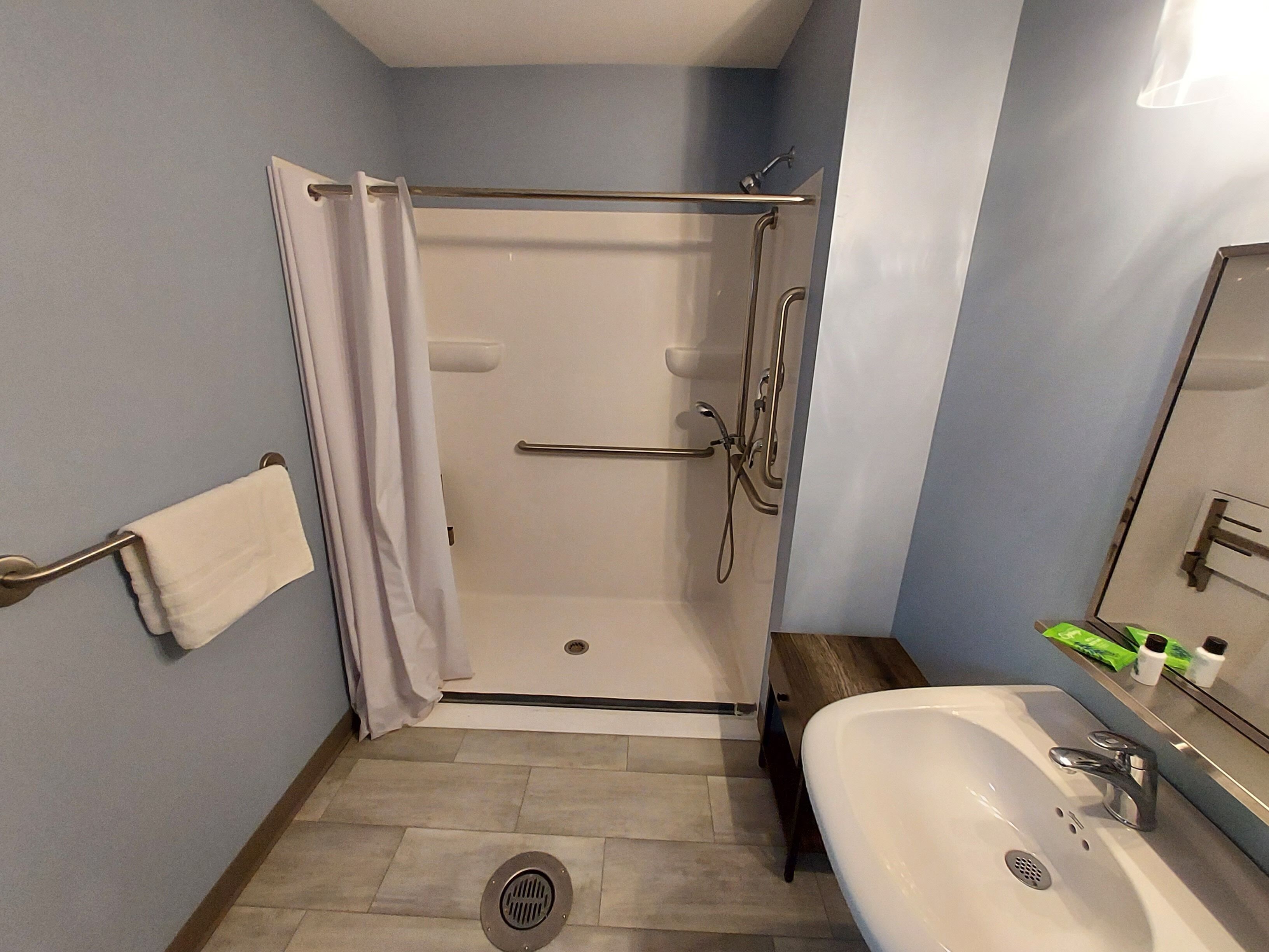Ein Badezimmer mit Dusche, Toilette, Waschbecken und Handtuchhalter.