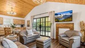 Un salon spacieux avec des canapés en cuir, une cheminée et une grande fenêtre offrant une vue panoramique.