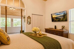 A bedroom with a bed, a dresser, a mirror, a painting, and a window with blinds. - Jeep Friendly Smoky Mountain Cabin with Views (Sevierville)
