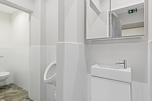 Een moderne badkamer met toilet, hygiëneschuimer en wastafel.