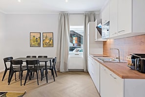 Eine moderne Küche mit weißen Schränken, einer Holzarbeitsplatte und einem eingebauten Backofen.