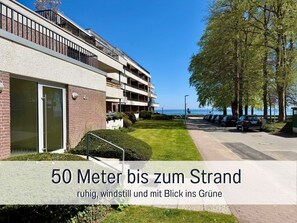 A modern building with a view of the sea, a well-maintained lawn, and a parking area. - WahlHeimat Haffkrug - Just a few steps from the sea (Scharbeutz)