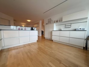 Eine geräumige Küche mit weißen Schränken und Holzboden.