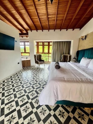 A bedroom with a bed, a wooden ceiling, a patterned floor, a window with curtains, and a chair. - HOTEL BOUTIQUE SAGRADO CORAZON  (Abejorral)