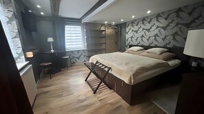A bedroom with a bed, a desk, a chair, a lamp, and a window with blinds. - Apartment Meise for 4 Guests (95 m²) in Sundern (Sundern (Sauerland))