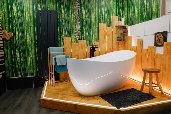 Ein modernes Badezimmer mit einer freistehenden Badewanne, Holzakzenten und einem Bambus-Dekor.