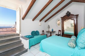 A bedroom with a bed, a chair, a table, and a staircase leading to an outdoor area. - YourHome - La Terrazza nel Blu (Piano di Sorrento)