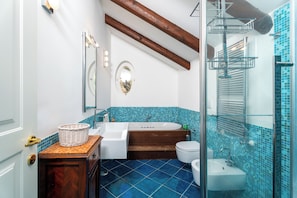 A bathroom with a bathtub, a toilet, a sink, and a shower area. - YourHome - La Terrazza nel Blu (Piano di Sorrento)