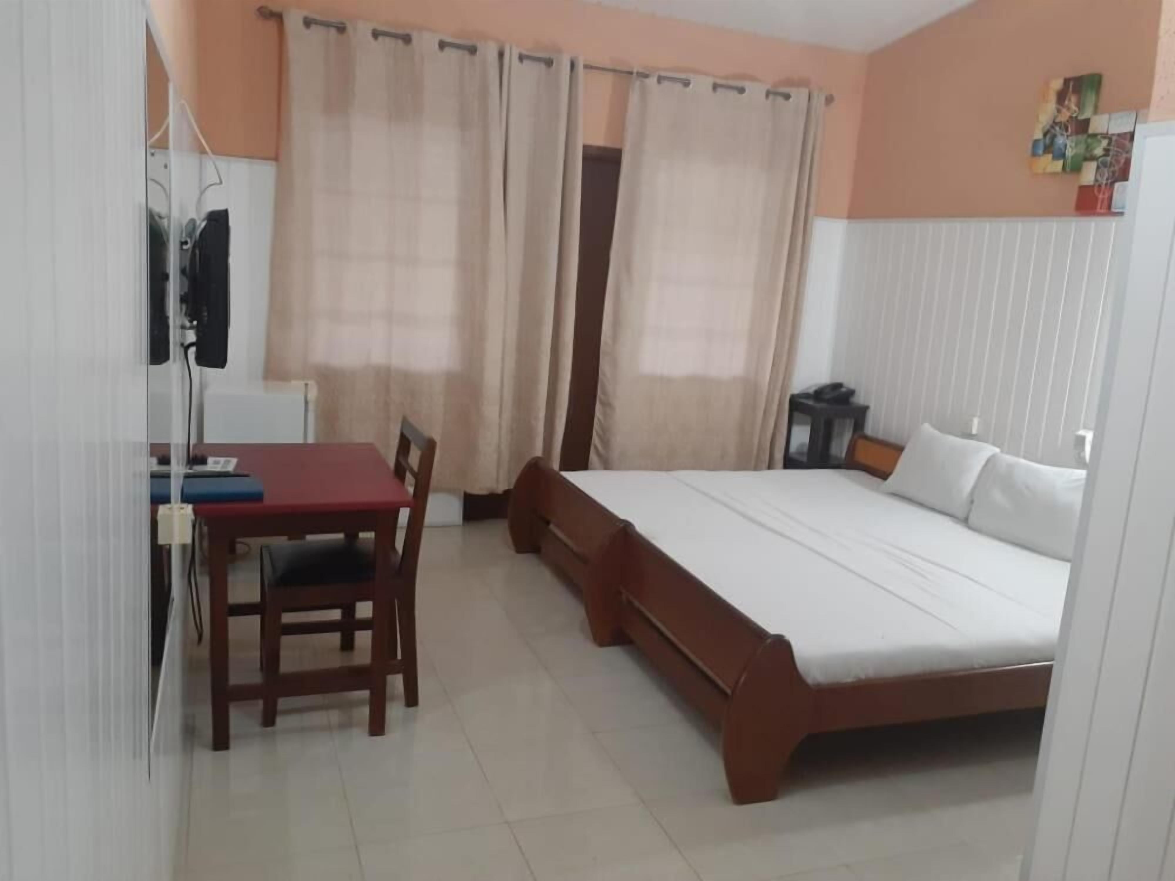Un dormitorio con una cama, un escritorio y una silla.