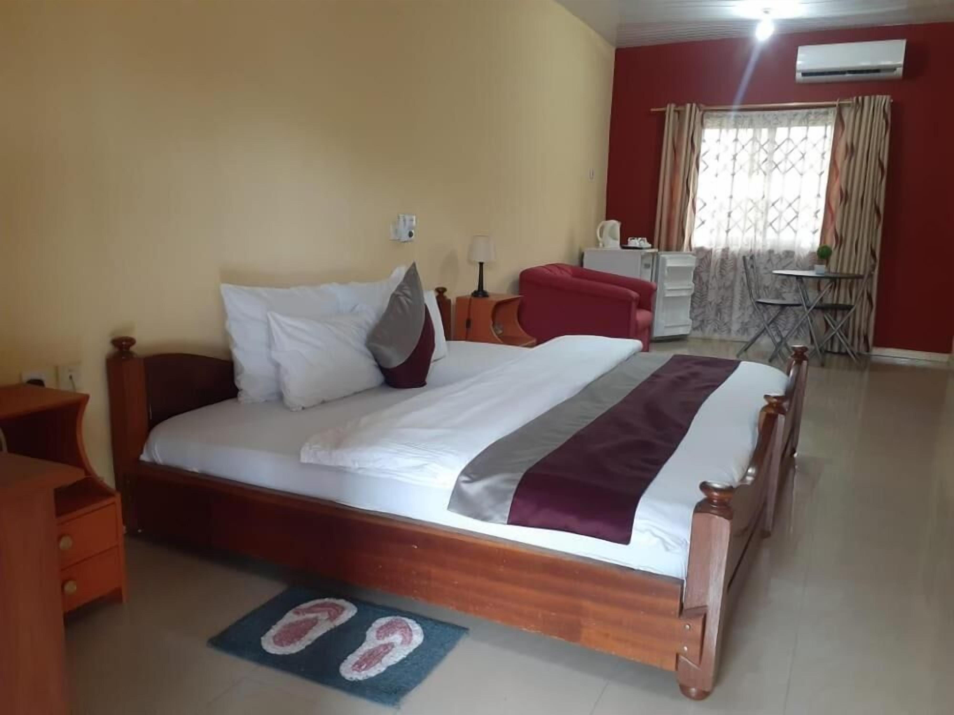 Un dormitorio con una cama de madera, un escritorio, una silla y una mesita de noche con una lámpara.