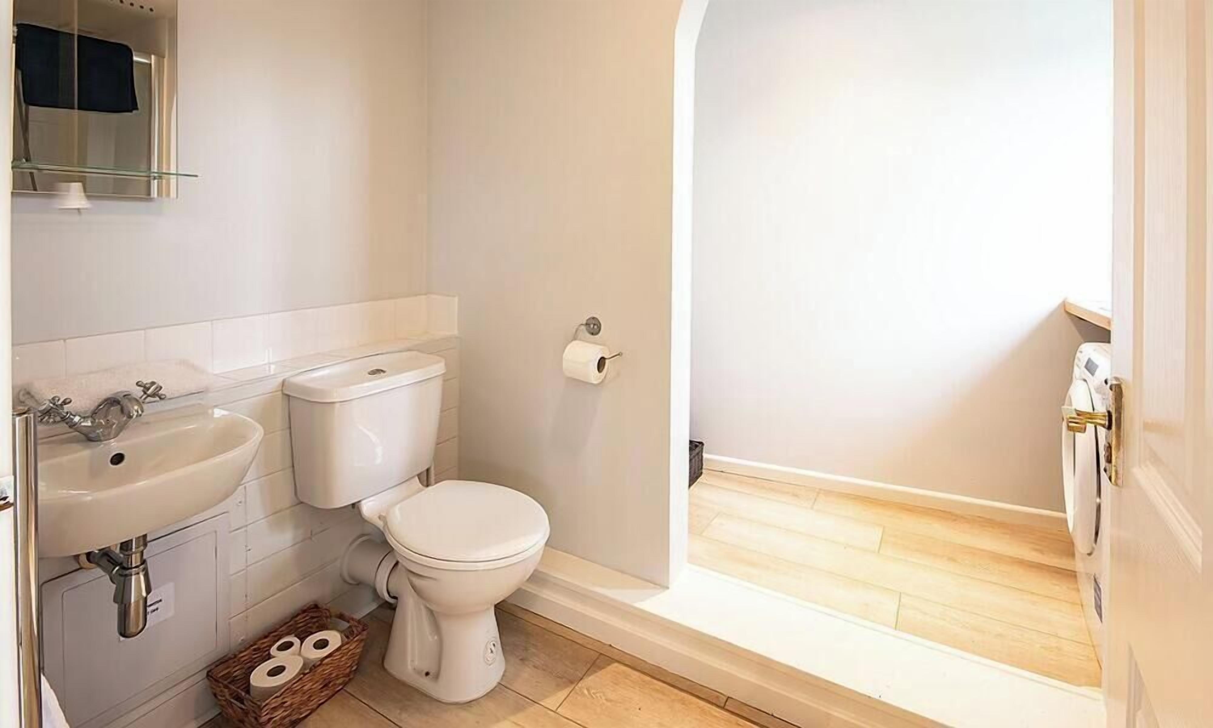 A bathroom with a toilet, sink, and shower.