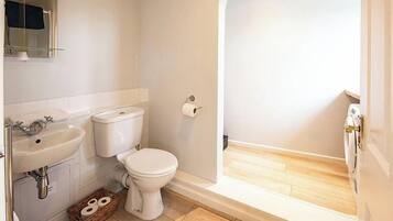 A bathroom with a toilet, sink, and shower.