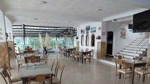 A spacious dining area with multiple tables and chairs, large windows, and a staircase. - HOTEL GIRON CAMPESTRE (Girón)