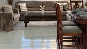 Ein modernes Wohnzimmer mit Sofa, Couchtisch und Essbereich.
