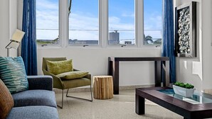 Ein modernes Wohnzimmer mit Sofa, Sessel, Beistelltisch und kleinem Couchtisch.