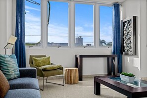 Ein modernes Wohnzimmer mit Sofa, Sessel, Beistelltisch und kleinem Couchtisch.