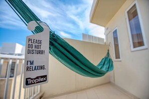 A hammock with a sign attached to it, a building, and a clear sky. - Charming bright penthouse with 3 Terraces JCUT2-1 (Swieqi)