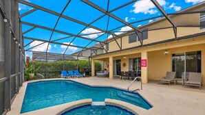 Una piscina interior con techo de vidrio, sillas de descanso y un jacuzzi.