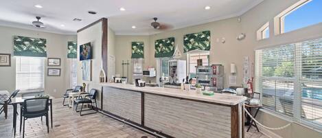 A spacious kitchen with a long counter, modern appliances, and a view of the street.