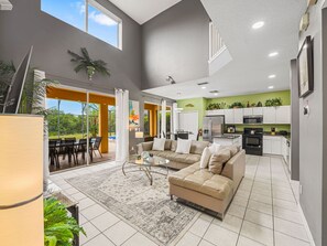A spacious living area with a sofa, coffee table, and a view of the outdoors. - 8579 La Isla Drive (Kissimmee)