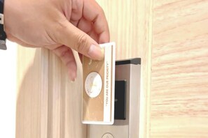 A hand holding a card with a circular design and text, placed on a wooden surface. - Priority Kalimantan Samarinda (Samarinda)