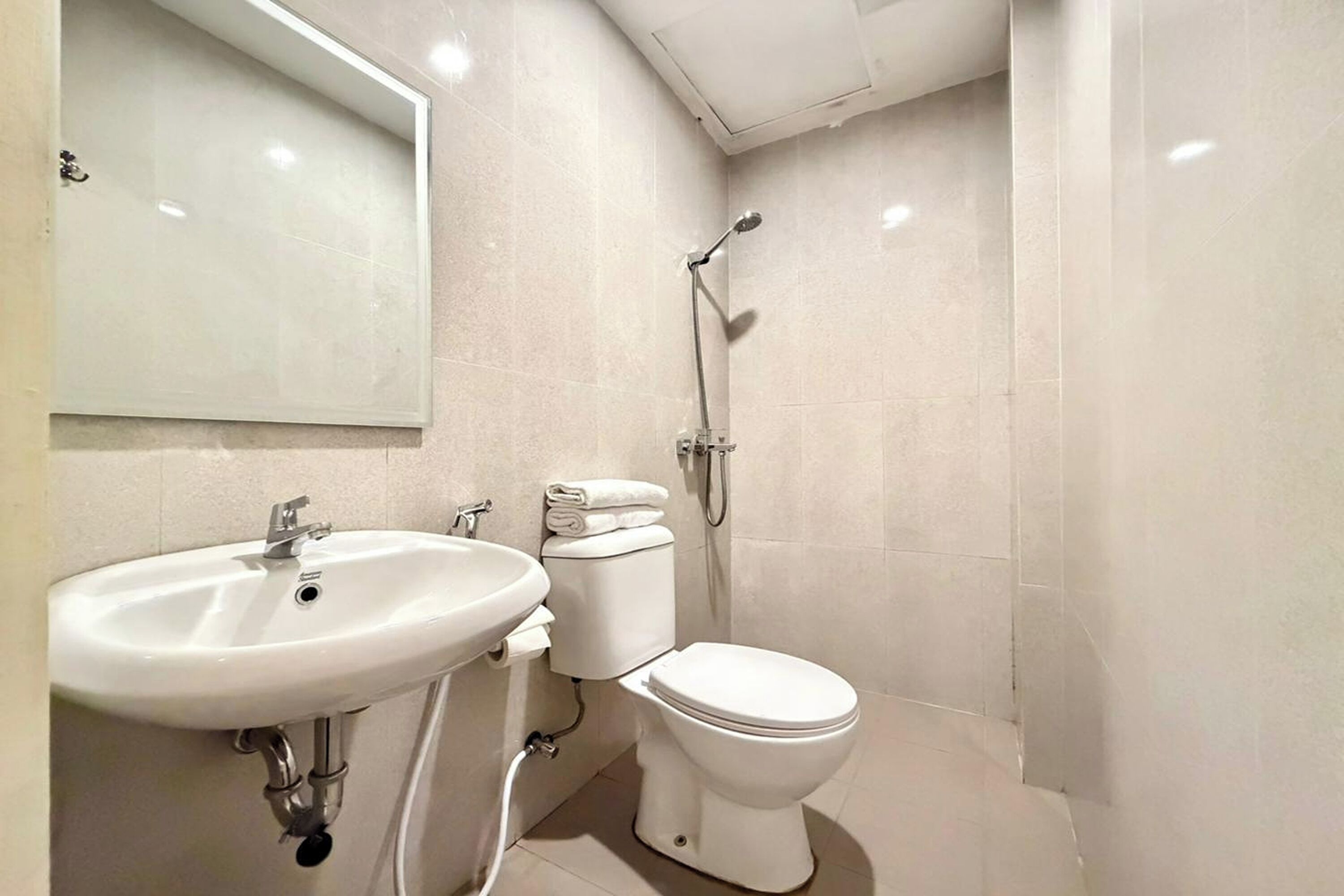A bathroom with a white sink, toilet, and shower.