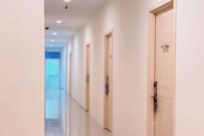 A corridor with doors on the right, a light-colored floor, and a ceiling with recessed lighting. - Priority Kalimantan Samarinda (Samarinda)