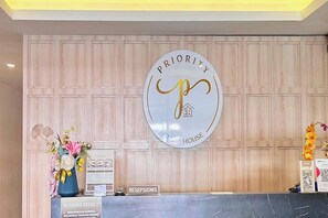 A reception desk with a sign reading 'Priority House' and a 'Reception' sign below it. - Priority Kalimantan Samarinda (Samarinda)