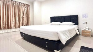 A hotel room with a bed, a nightstand, a telephone, and a window with curtains. - Priority Kalimantan Samarinda (Samarinda)