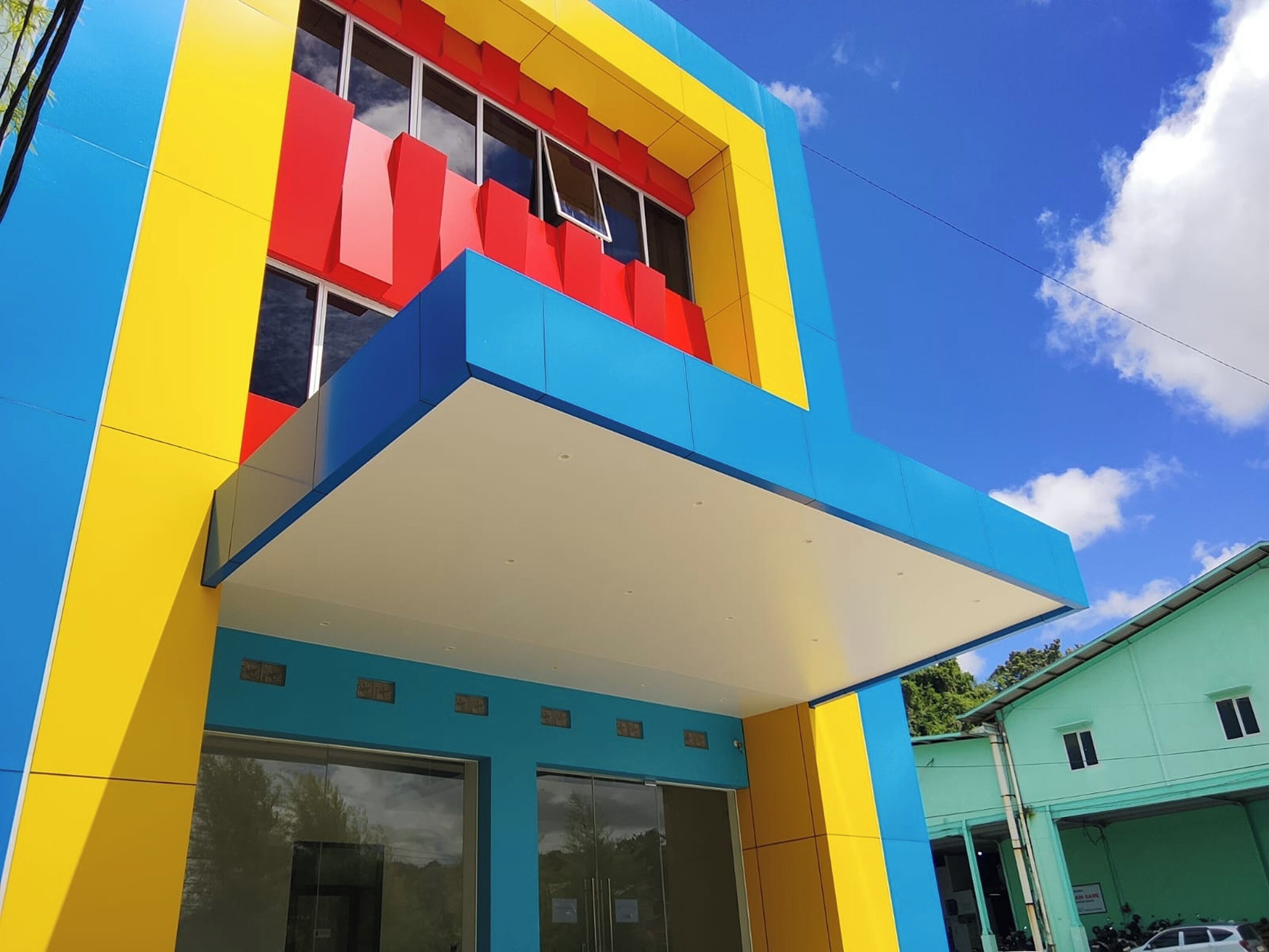 A multi-story building with a colorful facade, large windows, and a flat roof.