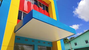 A multi-story building with a colorful facade, large windows, and a flat roof.