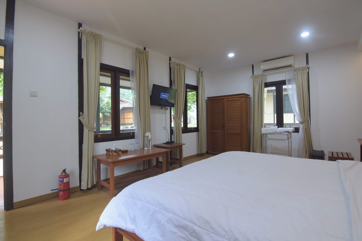 Une chambre d’hôtel avec un lit, une télévision, un bureau et une armoire.