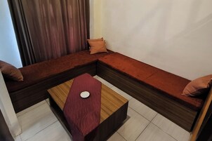 Una sala moderna con un sofá modular, una mesa de centro de madera y una alfombra roja.