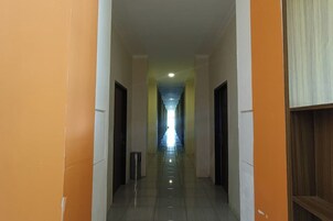 Un pasillo con puertas a ambos lados, que conduce a un final luminoso.