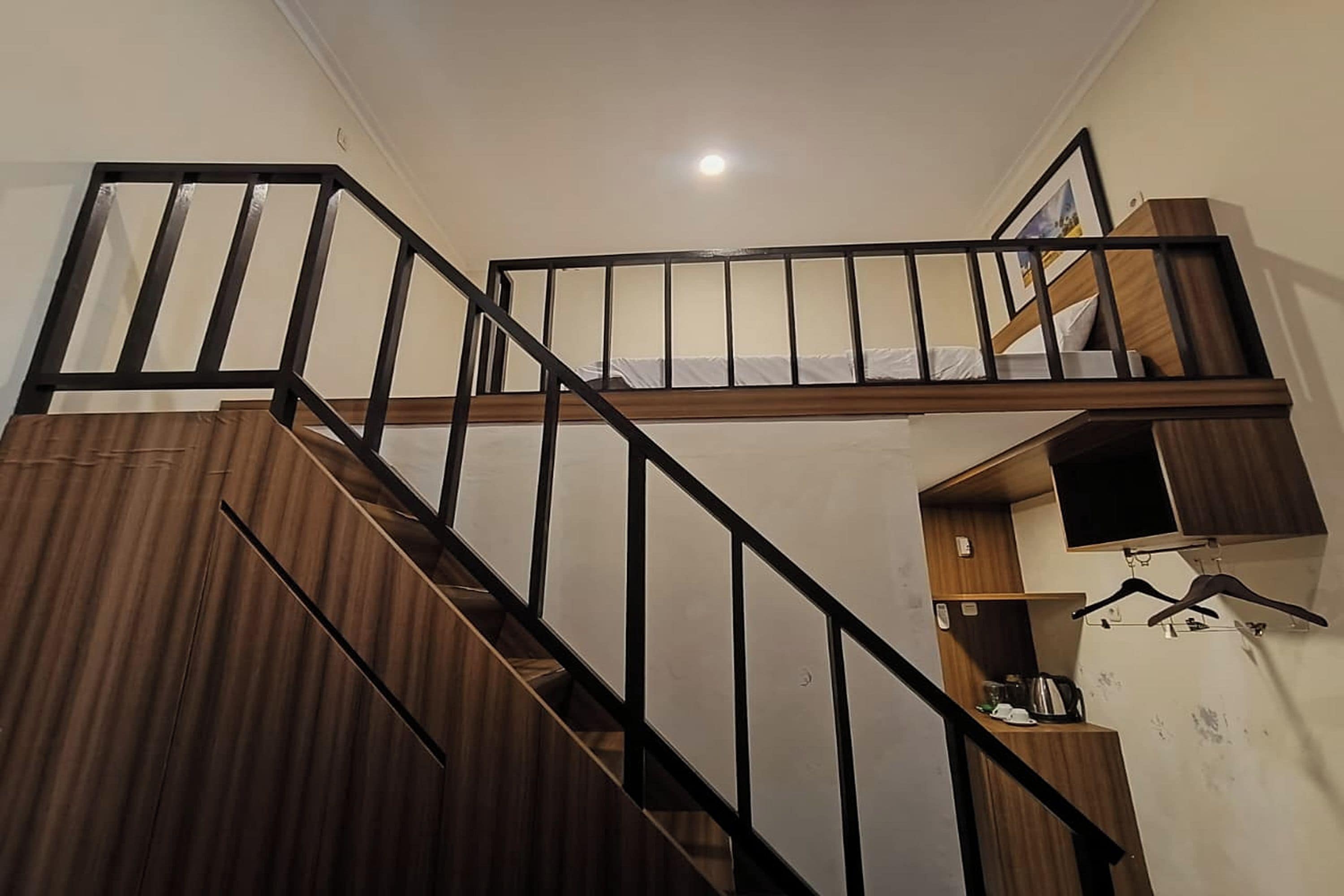 Una escalera con acabado de madera y barandillas negras.