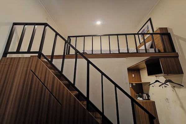 A staircase with a wooden finish and black railings.