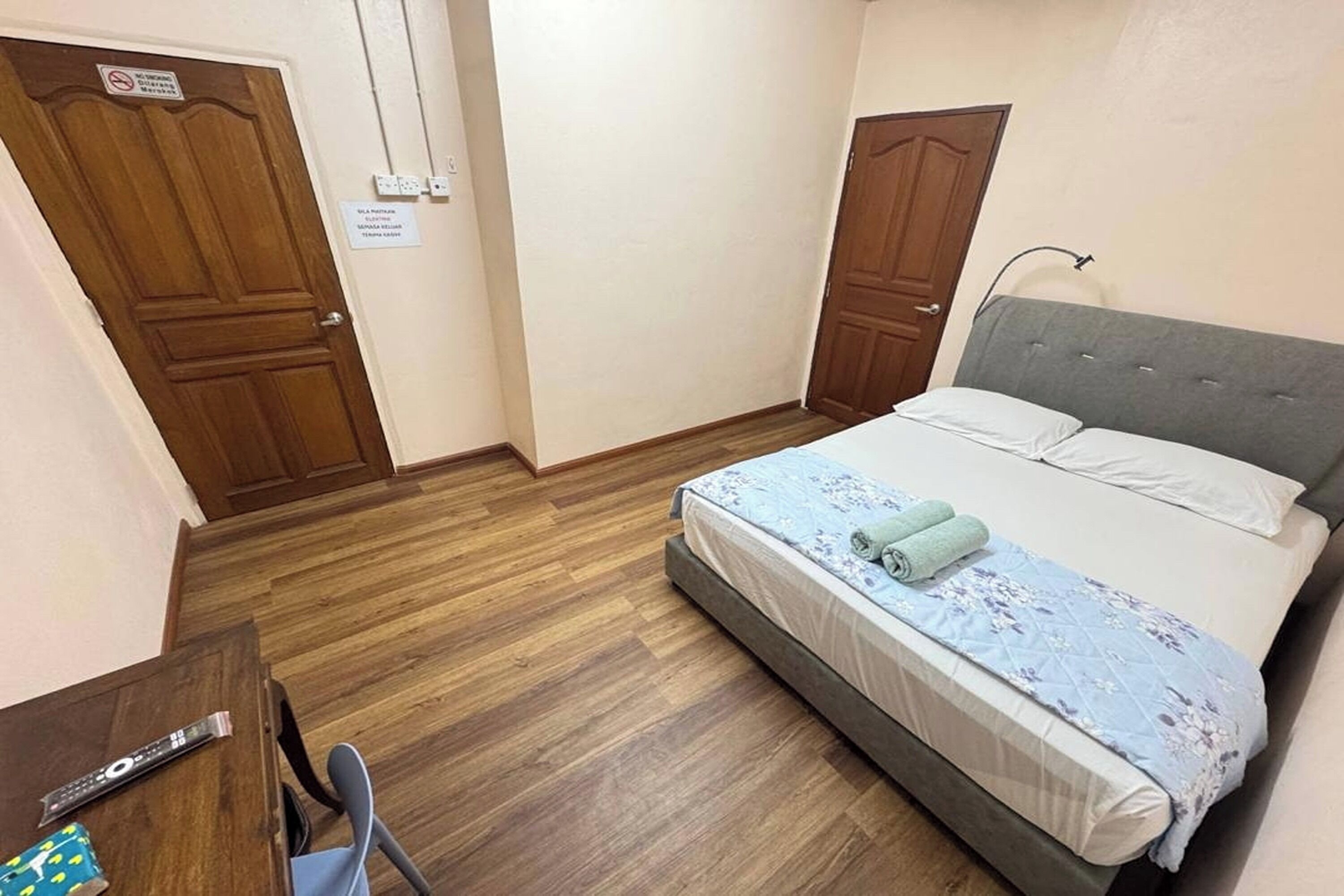A bedroom with a bed, a desk, and two doors.