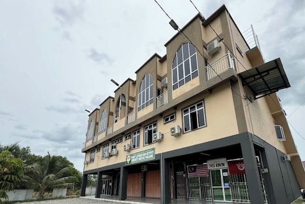 A multi-story building with a ground-level commercial space, including a restaurant and a sign for a local business.