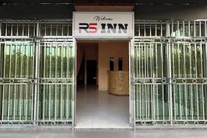A gated entrance to a hotel with a sign reading 'Welcome RS INN.'