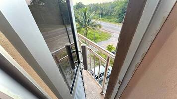 Un balcón con vista a una carretera y palmeras.