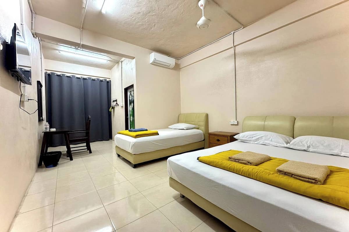 Una habitación de hotel con dos camas, un escritorio y una silla.