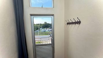 A door with a view of a parking lot and a small window above it.