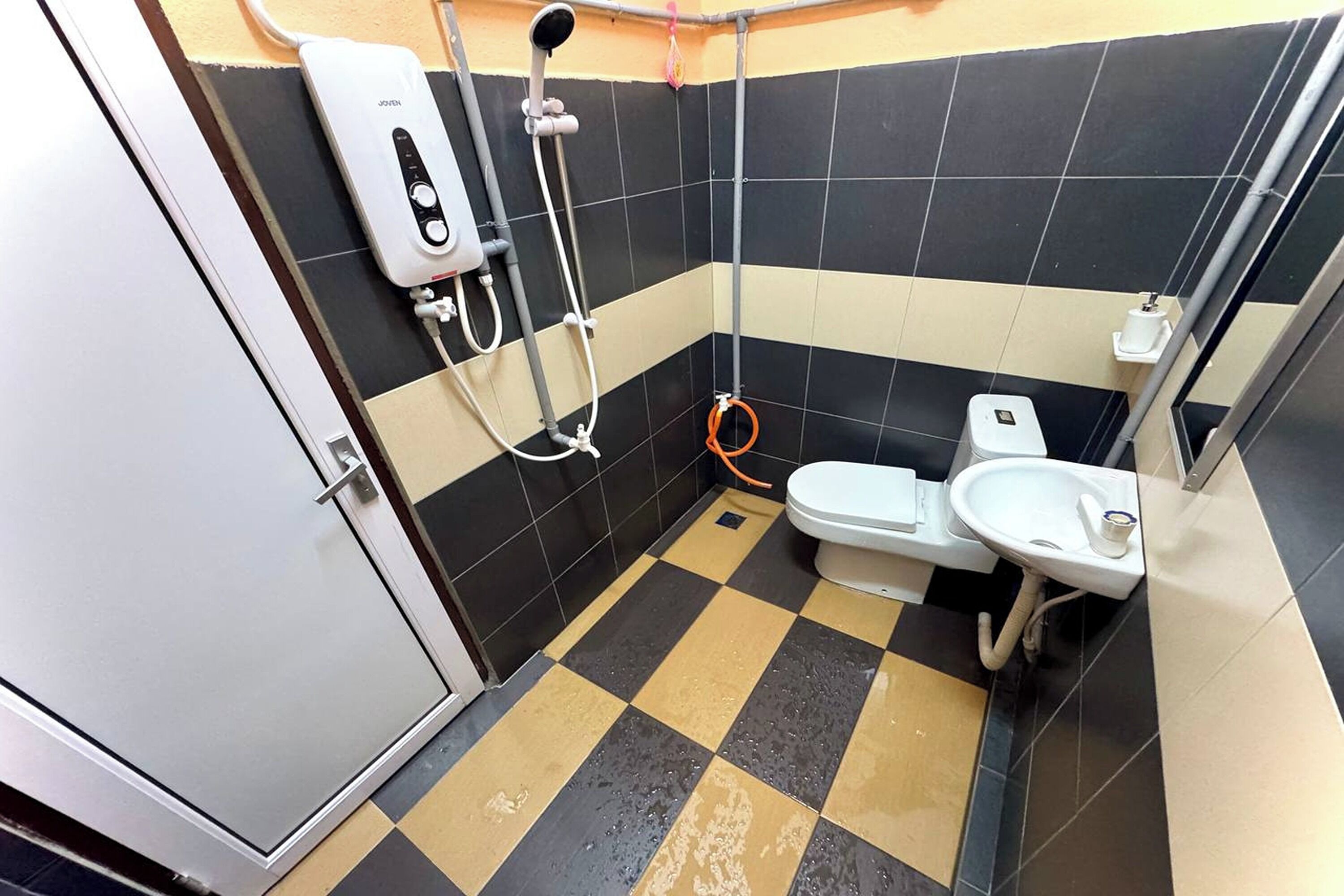 A small bathroom with a toilet, a sink, and a shower unit.