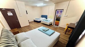 A compact room with a single bed, a small table, and a door with a sign. - Hotel Rs Inn (Pasir Mas)