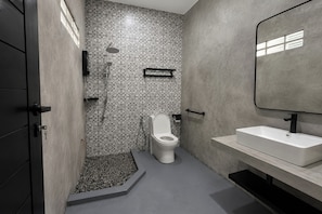 Une salle de bain moderne Ă©quipĂ©e dâune douche, de toilettes et dâun lavabo.