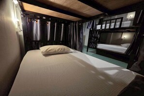 A bunk bed room with a single bed and a lower bunk. - Terminal Garage (Phuket)