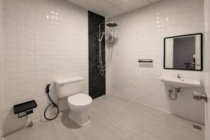 A modern bathroom with a toilet, shower, and sink. - Terminal Garage (Phuket)